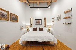 Room featuring high ceilings with exposed wood beams and track lighting - 