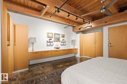 Exposed wood-beam ceilings and track lighting accentuate this room with polished concrete flooring - 