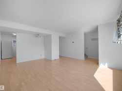 Spacious interior featuring light wood-finish flooring, white painted walls, and a semi-flush mount ceiling fixture - 