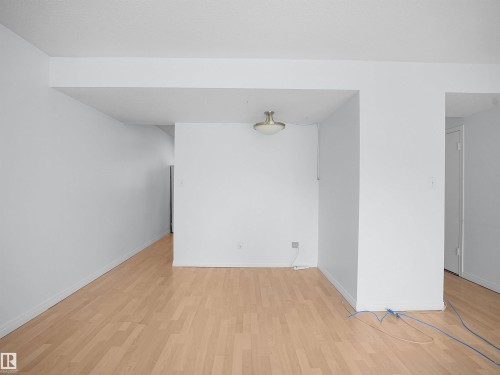 Spacious room featuring light wood-finish flooring, white walls, and a ceiling-mounted flush light fixture - 10446 55 Avenue Nw, Edmonton, AB - Indoor Photo Showing Other Room