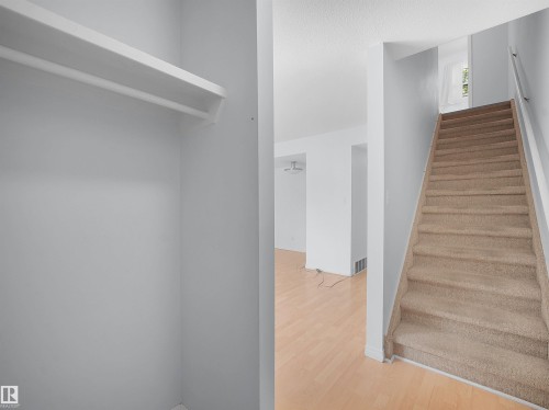 Integrated closet storage system with shelving and hanging rod - 10446 55 Avenue Nw, Edmonton, AB - Indoor Photo Showing Other Room