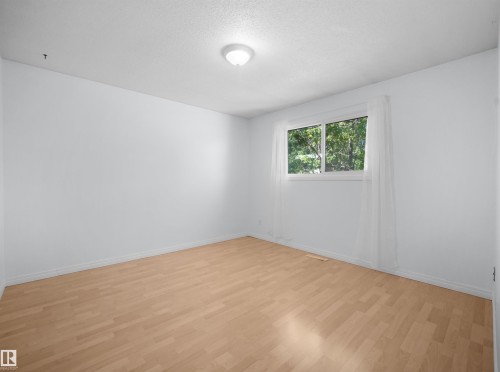 Room featuring light wood-finish flooring, white walls, and a window with white trim - 10446 55 Avenue Nw, Edmonton, AB - Indoor Photo Showing Other Room