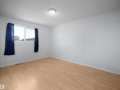 Bright room featuring light wood-finish flooring, white walls, and a large window - 10446 55 Avenue Nw, Edmonton, AB - Indoor Photo Showing Other Room