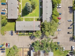 Aerial view showcasing a multi-unit property with a grey shingle roof - 