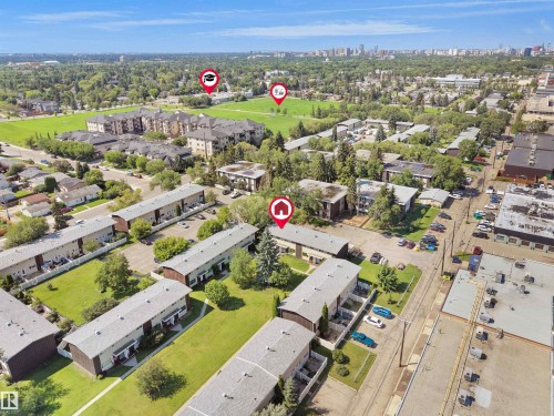 Aerial perspective of a multi-building residential complex surrounded by green spaces and mature trees - 10446 55 Avenue Nw, Edmonton, AB - Outdoor With View