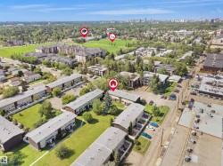Aerial perspective of a multi-building residential complex surrounded by green spaces and mature trees - 
