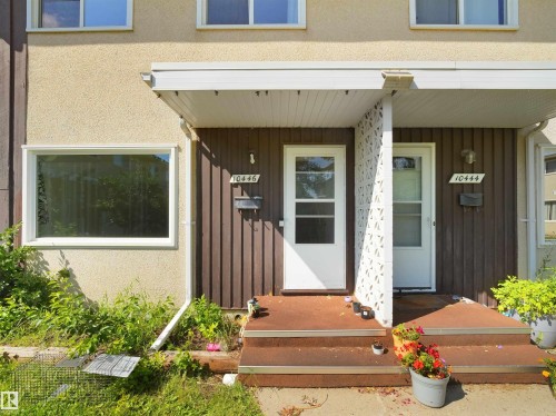Duplex exterior featuring stucco siding and vertical wood-finish paneling - 10446 55 Avenue Nw, Edmonton, AB - Outdoor With Exterior