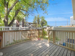 Spacious outdoor deck with natural wood flooring and coordinating wood railing - 