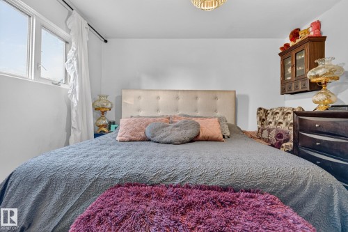 Room featuring an upholstered headboard, multiple windows with natural light, and a ceiling light fixture - 5307 104 Avenue Nw, Edmonton, AB - Indoor Photo Showing Bedroom