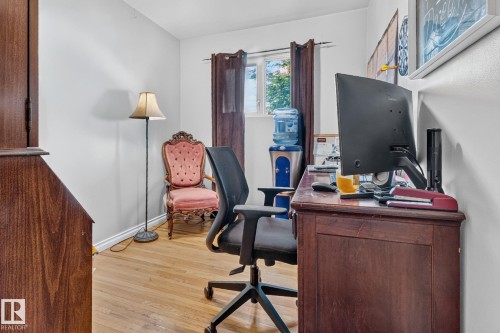 Room featuring wood-finish flooring, white walls, and a window with dark curtains - 5307 104 Avenue Nw, Edmonton, AB - Indoor Photo Showing Office
