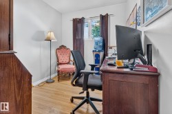 Room featuring wood-finish flooring, white walls, and a window with dark curtains - 