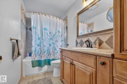 Bathroom featuring a vanity with a recessed sink, a framed mirror, and a combination tub/shower with tiled surround - 