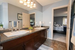 Dual vanity with granite-style countertop, undermount sinks, and chrome fixtures - 