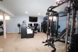 Spacious room featuring light blue walls, recessed lighting, and carpet flooring - 