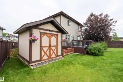 Wood-sided storage shed with double doors, set on a gravel bed - 
