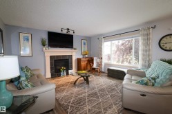 Living area featuring a fireplace with a white mantel and black tile surround - 