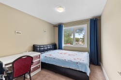 Carpeted bedroom featuring a large window, neutral wall paint, and a flush mount ceiling light - 