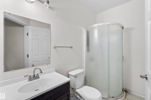 Bathroom featuring a dark wood-finish vanity with an integrated sink, polished chrome faucet, and track lighting - 11719 127 Street Nw, Edmonton, AB - Indoor Photo Showing Bathroom