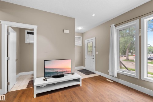 Living area with wood-finish flooring, neutral wall paint, and white trim - 11719 127 Street Nw, Edmonton, AB - Indoor