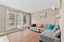 Living area featuring wood-finish flooring, recessed lighting, and a wall of three large windows - 11719 127 Street Nw, Edmonton, AB  - Indoor Photo Showing Living Room 