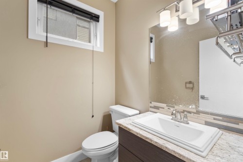 Vanity with a granite-style countertop, undermount sink, and chrome faucet - 11719 127 Street Nw, Edmonton, AB - Indoor Photo Showing Bathroom