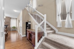 Carpeted staircase with white railings and metal spindles - 