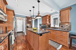 Kitchen featuring wood-finish cabinetry, dark stone countertops, and stainless steel appliances - 