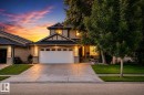 Two-story residence featuring a two-car garage, concrete driveway, and established front landscaping - 12720 Hudson Way Nw, Edmonton, AB  - Outdoor With Facade 