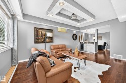 Recessed lighting and a decorative tray ceiling complement the wood-finish flooring - 