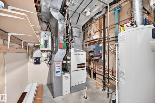 Utility room featuring a furnace, water heater, electrical panel, and exposed copper piping - 12720 Hudson Way Nw, Edmonton, AB - Indoor Photo Showing Basement