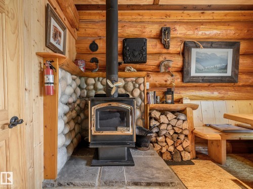 Wood-burning stove with a stone hearth and river rock surround - 58227 Range Rd 70 A, Rural St. Paul County, AB - Indoor With Fireplace