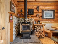 Wood-burning stove with a stone hearth and river rock surround - 