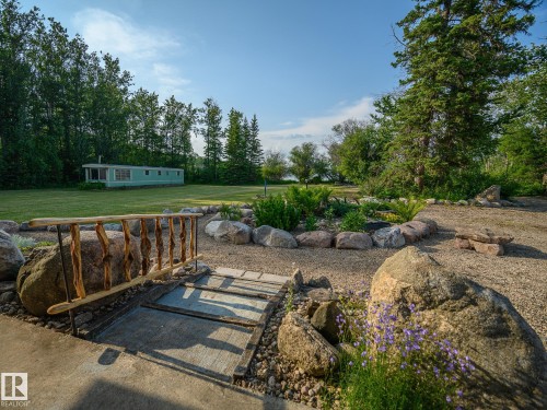 Gravel landscaping with a decorative log bridge and a stone-lined garden bed - 58227 Range Rd 70 A, Rural St. Paul County, AB - Outdoor