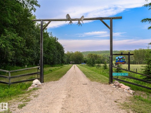 Gated entry with a gravel driveway, custom wooden archway, and antler accents - 58227 Range Rd 70 A, Rural St. Paul County, AB - Outdoor With View