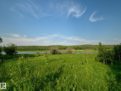 Expansive natural landscape with a calm body of water, bordered by dense tree lines, under a clear blue sky - 58227 Range Rd 70 A, Rural St. Paul County, AB - Outdoor With View