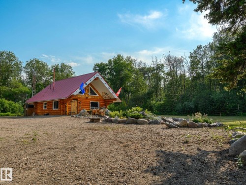 Log cabin exterior with a red metal roof and natural wood siding - 58227 Range Rd 70 A, Rural St. Paul County, AB - Outdoor