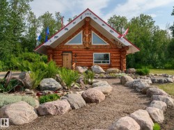 Log cabin exterior featuring a red-trimmed roofline and natural wood siding - 