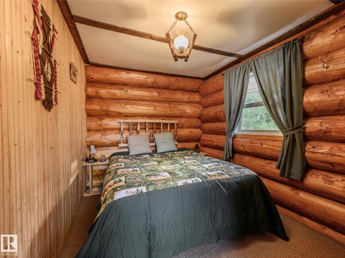 Log cabin interior featuring natural wood walls and ceiling beams - 58227 Range Rd 70 A, Rural St. Paul County, AB - Indoor Photo Showing Bedroom