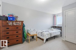 Room featuring light gray walls, textured white ceiling, light-colored carpet flooring, and a white paneled door - 
