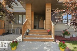 Exterior entry featuring a wooden front door, wooden staircase with railing, house number 79, and a gravel and concrete pathway - 