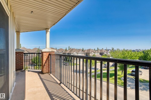 Covered balcony featuring a concrete surface, black metal railing, and brick pillars - #317 3719 Whitelaw Ln Nw, Edmonton, AB - Outdoor With Balcony With Exterior