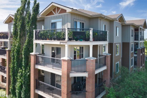 Multi-story building featuring balconies with black railings, brick columns, and a combination of vertical and horizontal siding - #317 3719 Whitelaw Ln Nw, Edmonton, AB - Outdoor With Balcony