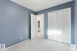 Room featuring light blue walls, white trim, and light-colored carpeting - 