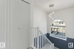 Arched window with decorative grilles, complemented by a contemporary multi-globe pendant light fixture - 