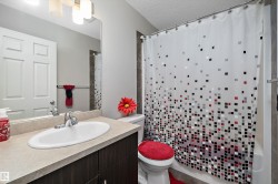 Bathroom vanity featuring a light-toned countertop, undermount sink, and dark wood-finish cabinetry - 
