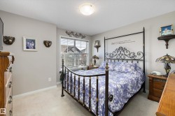 Carpeted bedroom featuring neutral wall paint and a large window with horizontal blinds - 