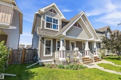 Gable-front home featuring gray siding with white trim accents and a covered porch - 