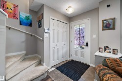 Entryway featuring a white paneled door with glass insert, dual bi-fold closet doors, and recessed ceiling lighting - 
