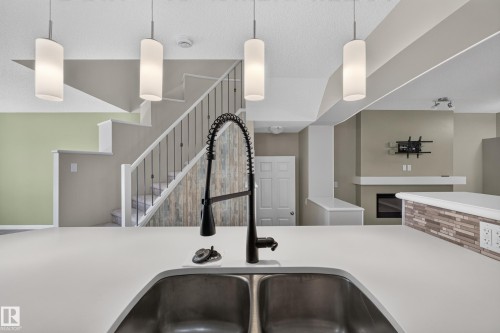Contemporary double basin kitchen sink with a matte black high-arc faucet, set within a light-toned countertop - 3139 Carpenter Landing Sw, Edmonton, AB - Indoor Photo Showing Kitchen With Double Sink