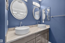 Contemporary double vanity featuring vessel sinks, polished chrome hardware, an integrated backsplash, and a patterned tile accent - 